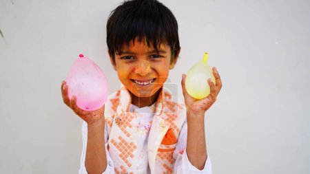 Foto de Feliz linda sonrisa buscando niños jugando con pinturas en los dedos. Holi Festival de colores. India Festival de colores. - Imagen libre de derechos
