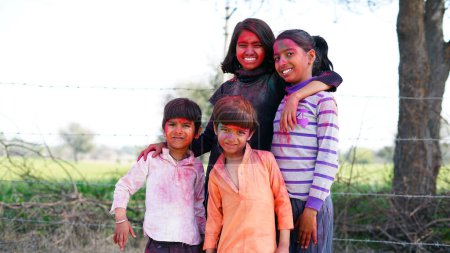 Téléchargez les photos : Enfants indiens heureux jouant des couleurs, souriant avec des couleurs sur le visage ou des enfants asiatiques célébrant Holi. Concept pour le festival indien Holi. Enfants brillants enduits de poudre colorée - en image libre de droit