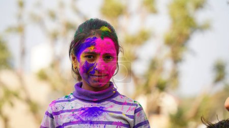 Foto de Chico soplando polvo de color holi de la mano durante la celebración del festival Holi - Concepto de niños pequeños divirtiéndose jugando holi durante la fiesta - Imagen libre de derechos