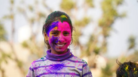 Foto de Joven lindo niños alegres con colores holi aplicados en polvo mostrando manos coloridas a la cámara durante la celebración del festival holi - Imagen libre de derechos