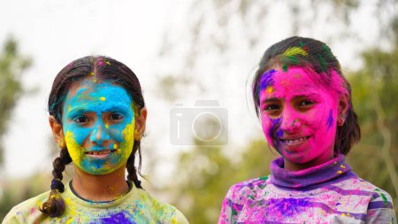 Happy Cute Smiling looking kids playing with paints in their fingers. Holi Festival of colors. India Festival of colours.