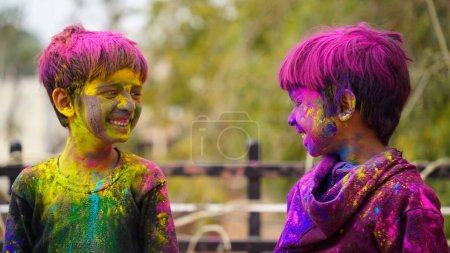 Foto de Feliz linda sonrisa buscando niños jugando con pinturas en los dedos. Holi Festival de colores. India Festival de colores. - Imagen libre de derechos