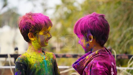 Foto de Niños cubiertos de polvo de colores durante el festival de Holi. Happy Cute niños asiáticos celebran el festival de la India holi con colorido polvo de pintura en las caras y el cuerpo - Imagen libre de derechos
