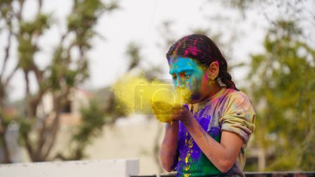 Téléchargez les photos : Heureux mignon souriant regardant les enfants jouer avec des peintures dans leurs doigts. Holi Festival des couleurs. Inde Festival des couleurs. - en image libre de droit