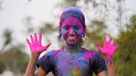Téléchargez les photos : Joyeux mignon sourire petits enfants indiens montrant leurs mains colorées ou l'impression de la paume ou jouer holi festival avec des couleurs - en image libre de droit
