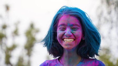Foto de Joven lindo niño alegre niña con aplicado holi colores polvo mostrando manos coloridas a la cámara durante la celebración del festival holi - Imagen libre de derechos