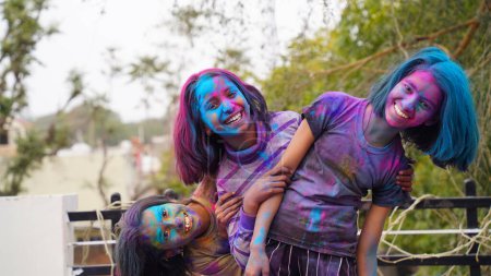 Téléchargez les photos : Heureux amis indiens ou enfants célébrant le festival hindou de Holi en appliquant des couleurs les uns aux autres, meilleurs amis. Frères et soeurs femelles tenant une assiette avec différentes nuances de Gulal - en image libre de droit