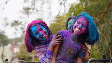 Téléchargez les photos : Enfants couverts de poudre colorée pendant le festival de Holi. heureux mignon asiatique enfants célébrer indien holi festival avec coloré peinture poudre sur visages et corps - en image libre de droit