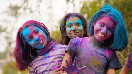 Téléchargez les photos : Enfants indiens heureux jouant des couleurs, souriant avec des couleurs sur le visage ou des enfants asiatiques célébrant Holi. Concept pour le festival indien Holi. Enfants brillants enduits de poudre colorée - en image libre de droit