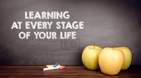 Foto de Aprender en cada etapa de tu vida. Manzanas en el escritorio del profesor. - Imagen libre de derechos