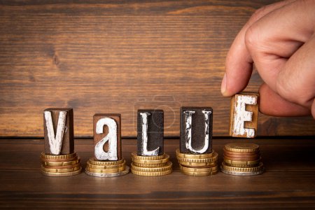 Value concept. Text and money on wood texture background.
