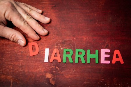 Foto de DIARRHEA. Health concept. Colorful letters of the alphabet on a wooden background. - Imagen libre de derechos