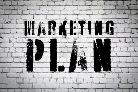 Téléchargez les photos : Concept de plan marketing. Texte peint sur un mur de briques. - en image libre de droit