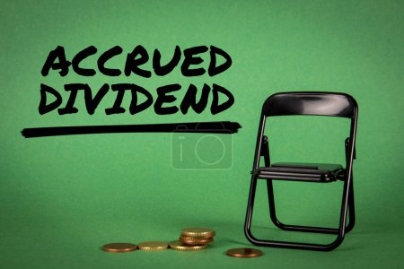 Photo for ACCRUED DIVIDEND. Miniature chair and change on a green background. - Royalty Free Image