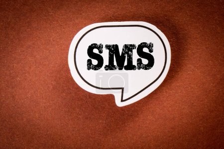 SMS. Speech bubble with text on brown background.