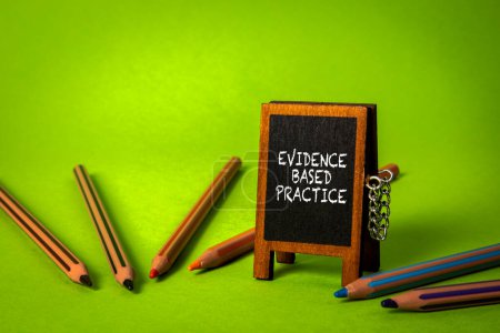 Photo for Evidence based practice. Miniature chalk board on a green background. - Royalty Free Image
