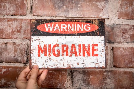 Photo for MIGRAINE. Warning sign with text on brick wall background. - Royalty Free Image