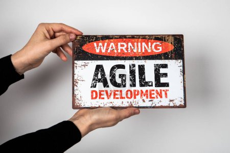 Photo for AGILE DEVELOPMENT. Warning sign with text in the hands of a woman. - Royalty Free Image