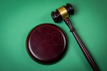 Téléchargez les photos : Marteau de cour en bois sur fond vert. Le droit et le concept de procès équitable. - en image libre de droit