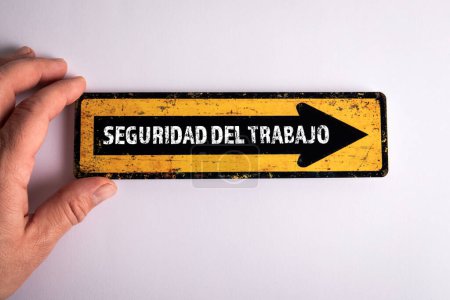 Téléchargez les photos : Concept de sécurité au travail. Texte sur la flèche de direction en espagnol. - en image libre de droit