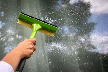 Téléchargez les photos : Brosse de nettoyage des fenêtres pour le lavage des fenêtres. L'extérieur de la maison. - en image libre de droit
