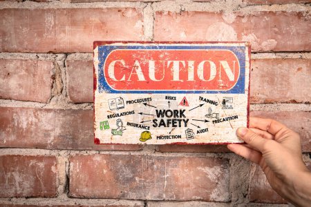 Téléchargez les photos : Sécurité au travail. Signe de prudence dans une main de femme sur un fond de brique. - en image libre de droit