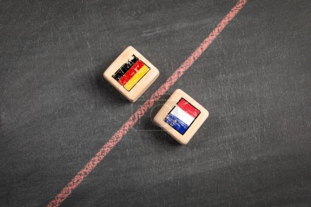 Germany vs France concept. Wooden blocks on a dark chalkboard background.