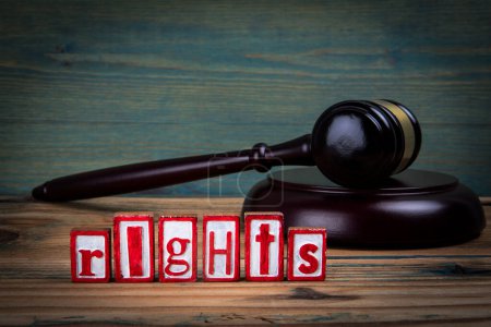 RIGHTS. Red alphabet letters and judges gavel on wooden background. Laws and justice concept.