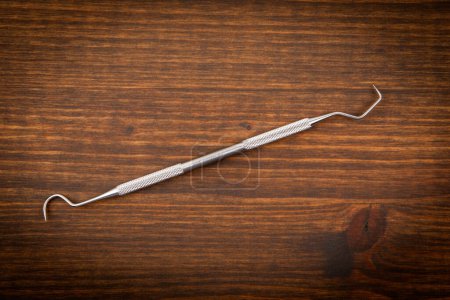Photo for Dental hygienist instrument on wooden background. Learning and professionalism. - Royalty Free Image