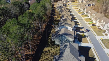 Téléchargez les photos : Vue aérienne rue résidentielle avec cul-de-sac le long de la rangée de nouveaux développements maisons de deux étages entourées de grands parcs de pins banlieues Atlanta, Géorgie, États-Unis. Subdivision suburbaine à haute densité - en image libre de droit