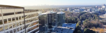 Photo for Panorama view modern glass wall corporate buildings at Tech Square neighborhood with Atlanta downtown skyscrapers in background. High-rise office park in Midtown near major Interstate highway I-85 - Royalty Free Image