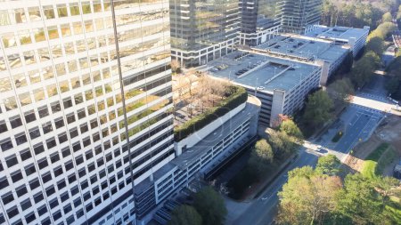 Photo for Aerial view glass windows corporate buildings with multi level garage in Tech Square neighborhood Midtown Atlanta, Georgia, USA. Close-up modern giant skyscrapers near major Interstate highway I-85 - Royalty Free Image