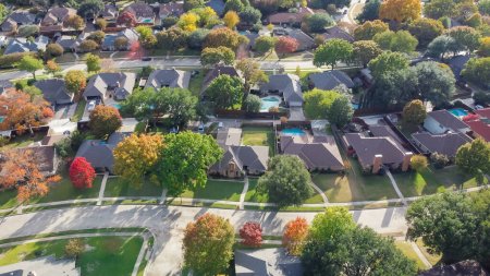 Maison individuelle haut de gamme avec piscine et feuillage d'automne coloré près de Dallas, Texas, Amérique. Vue aérienne un quartier résidentiel de banlieue établi feuilles d'automne lumineuses, grande rue