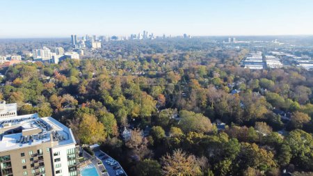 Foto de Típico edificio de apartamentos condominio con piscina en Brookwood Hills barrio rodeado de hojas de otoño follaje colorido otoño y centro de Atlanta vista aérea de fondo. Cielo azul claro y soleado - Imagen libre de derechos
