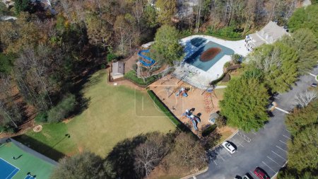 Photo for Aerial view typical recreational facilities in upscale residential neighborhood playground, tennis court complex, small community park suburbs Atlanta, Georgia, USA. Woodland area lush green houses - Royalty Free Image