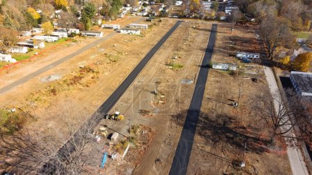 Foto de Top view large mobile home park construction site with private concrete street, slab foundation, heavy machines and row of completed manufactured houses in Rochester, New York, USA. Low income housing - Imagen libre de derechos