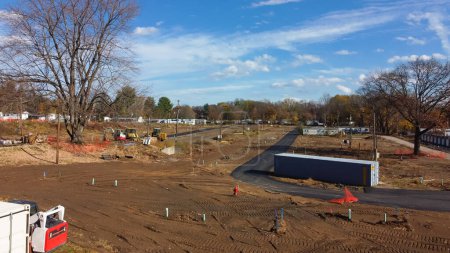 Foto de Slab foundation with drainage pipeline marks and heavy duty machine at construction site of mobile home park in Rochester, New York, USA. Aerial view manufactured houses in trailer park community - Imagen libre de derechos