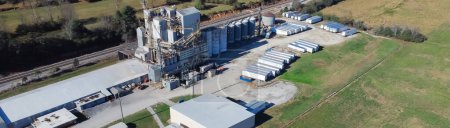 Téléchargez les photos : Panorama aerial a large animal nutrition premix plant with silos, tanker, shipping containers and heavy industrial machinery in Flowery Branch, Georgia, America. Nutrition feed producers facility - en image libre de droit