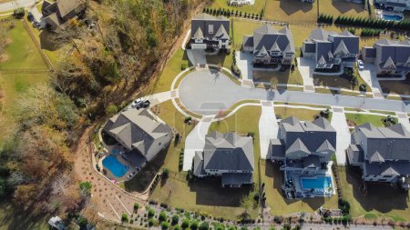 Téléchargez les photos : Aerial view upscale new development two story house with swimming pool and well trimmed yards near cul-de-sac of residential neighborhood suburbs Atlanta, Georgia, US. Large suburban home shingle roof - en image libre de droit