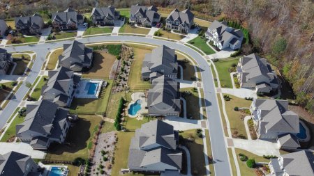 Téléchargez les photos : Row of two story houses with swimming pool, large backyard and well trimmed front yard in upscale residential neighborhood outside Atlanta, Georgia, US. Aerial suburban home shingle roof front garage - en image libre de droit