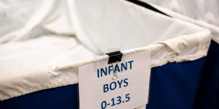 Photo for Row of empty infant boys shoes drives large vinyl coated nylon box truck containers at donation center in Dallas, Texas, USA, donation please needed. Social issue concept background - Royalty Free Image