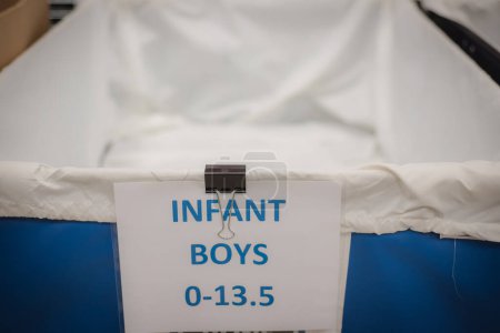 Photo for Toned photo empty infant boys shoes drives large vinyl coated nylon box truck containers at donation center in Dallas, Texas, USA, donation please needed. Social issue concept background - Royalty Free Image