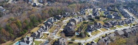 Téléchargez les photos : Panorama view row of new developments houses in master planned subdivision with lush green trees and natural trails outside Atlanta, Georgia, US. Aerial urban sprawl suburban residential neighborhood - en image libre de droit