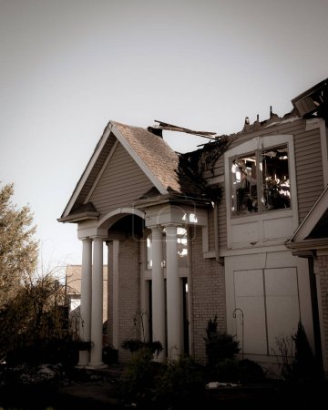 Téléchargez les photos : Toned photo ruined two story houses with shingle roof and front garage destroyed by fire in Rochester, Upstate New York, USA. Aftermath of wooden residential home disaster for insurance claim concept - en image libre de droit