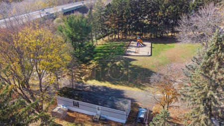 Foto de Aerial view Linden Avenue highway and mobile home trailer park with beautiful autumn leaves in Rochester, Upstate New York, USA. Prefabricated modular house suburban residential neighborhood - Imagen libre de derechos