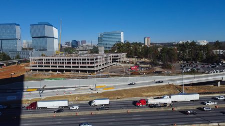 Téléchargez les photos : Large construction sites of high-rise office buildings and highway along Interstate 285 (the Perimeter) and Ashford Dunwoody road in midtown Atlanta, Georgia, USA. Aerial view skylines, busy traffic - en image libre de droit