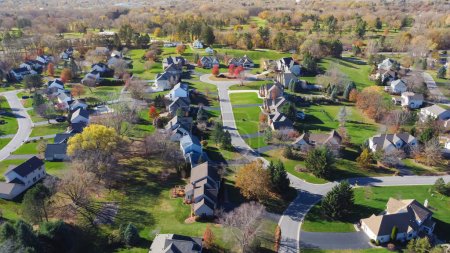 Cul-de-sac street in an established neighborhood with low density housing design and colorful autumn leaves in suburban Rochester, Upstate New York, USA. Aerial view upscale houses fall foliage