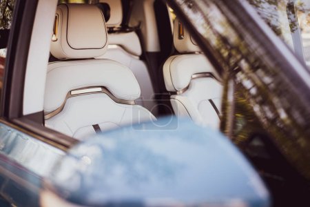 Téléchargez les photos : Focus sélectif à travers le miroir dans les sièges de conduite en cuir artificiel ergonomie design de sport rembourrage en cuir synthétique sur voiture neuve. Intérieur de la voiture de luxe - en image libre de droit