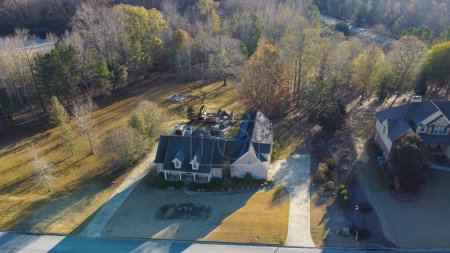 Téléchargez les photos : Vue aérienne Maison de banlieue de deux étages avec grand terrain près de la rue résidentielle dans une zone de verdure luxuriante avec un design de logement de faible densité à l'extérieur d'Atlanta, Géorgie, États-Unis. Nouvelle communauté de développement haut de gamme - en image libre de droit