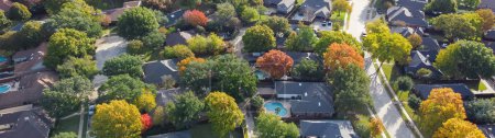 Foto de Panorama calle residencial bastante curvada y coloridas hojas de otoño que rodean las casas residenciales con piscina, patio trasero cercado en el exclusivo barrio Dallas, Texas, EE.UU.. Subdivisión aérea - Imagen libre de derechos